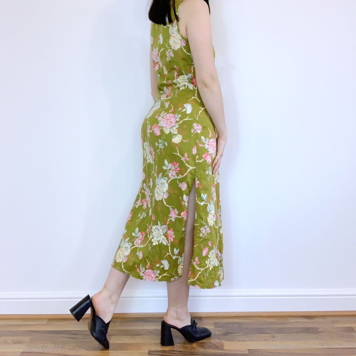 Emily posing in a sleeveless floral green cheongsam style dress