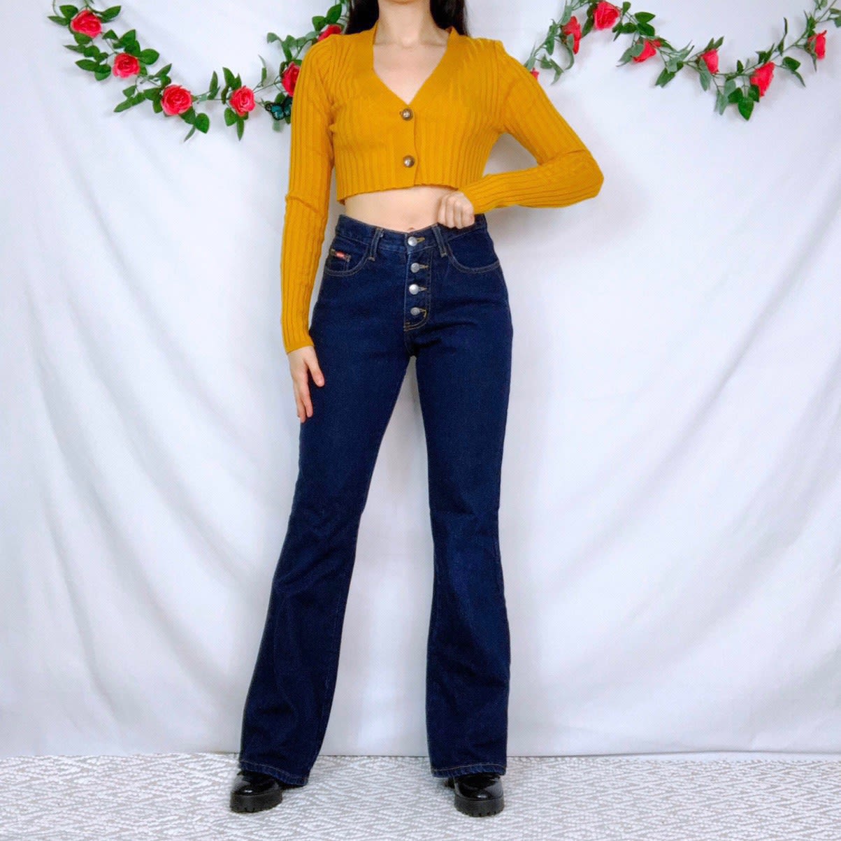 Emily posing in blue flared mid rise buttoned jeans