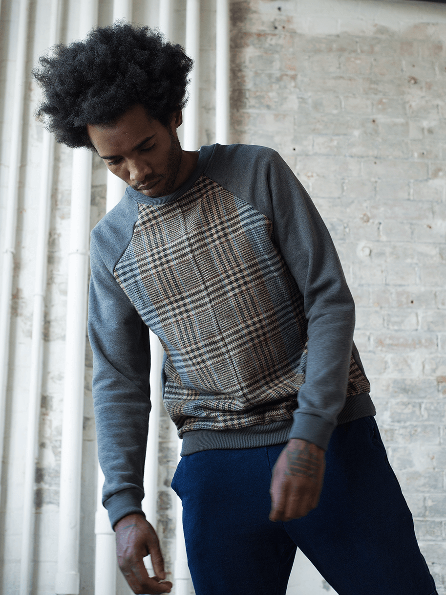 Model posing in a light grey sweatshirt with tweed detailing on the chest