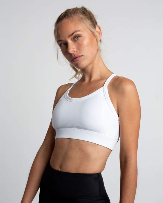 Model posing in a plain white sports bra